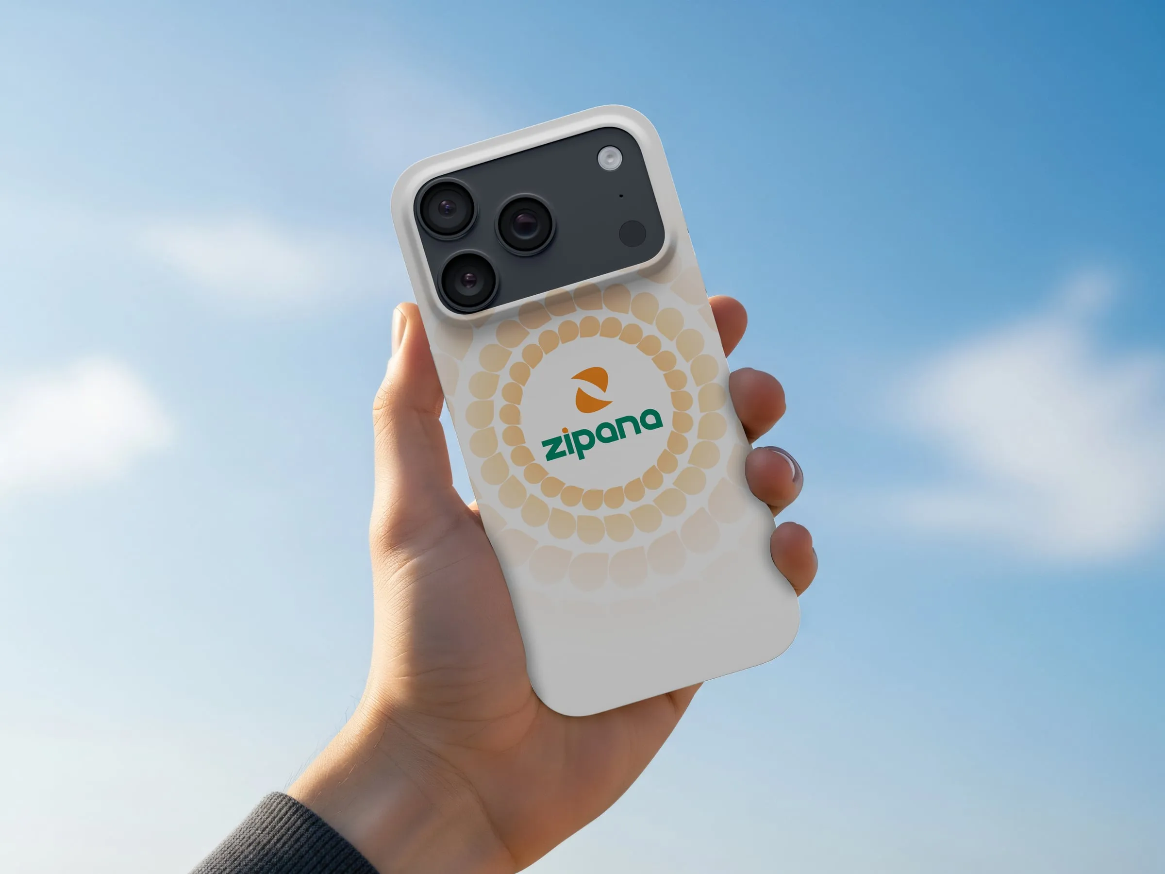 A hand holding up a phone in a Zipana case against a blue sky